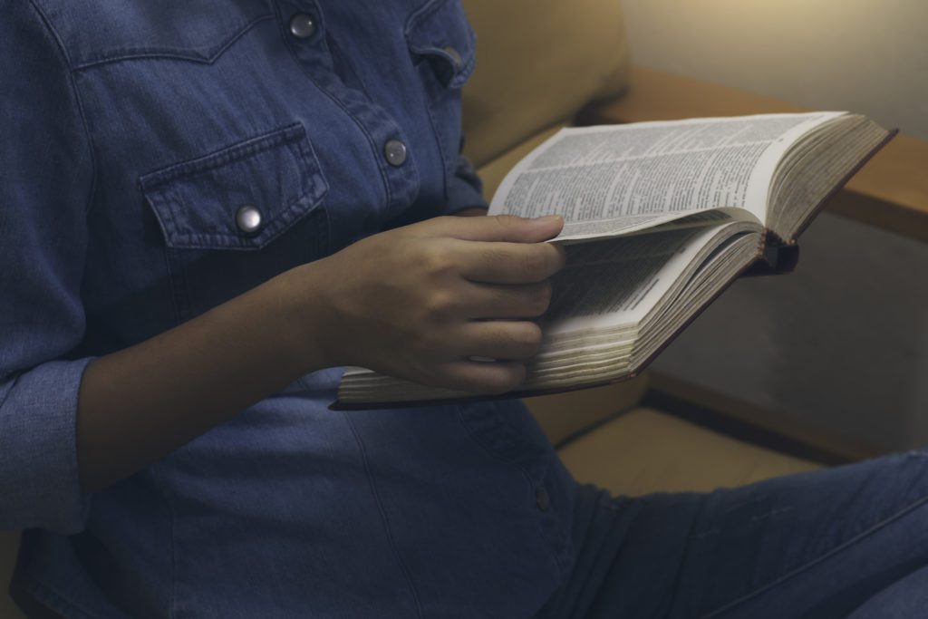 Woman reading a book while sitting down